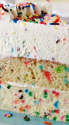 a slice of cake with white frosting and sprinkles