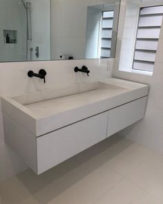 a white bathroom sink sitting under a large mirror