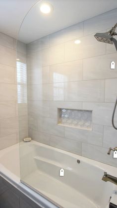 a bath tub sitting inside of a bathroom next to a shower head and faucet