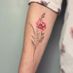 a woman's arm with a flower tattoo on the left side of her arm