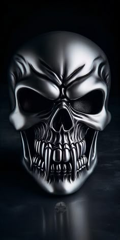 a silver skull with fangs on it's face is shown in the middle of a black background