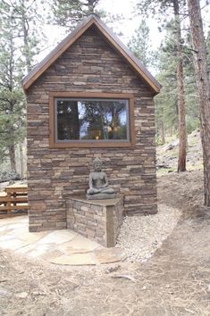 a small stone building with a buddha statue