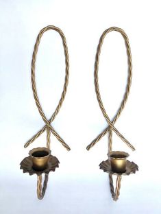 two metal candlesticks with twisted handles on white background