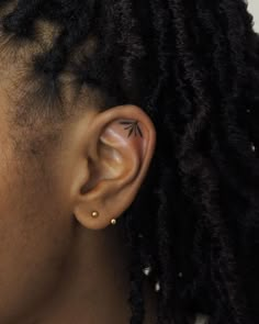 a close up of a person's ear with an arrow tattoo on the side