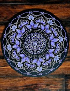 a purple and black plate sitting on top of a wooden floor