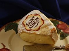 a piece of cheese sitting on top of a plate next to a knife and fork