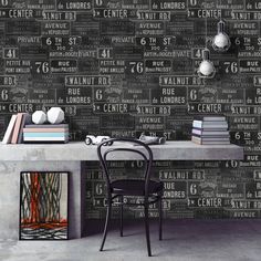 a room with a desk, chair and wallpaper that has different types of words on it