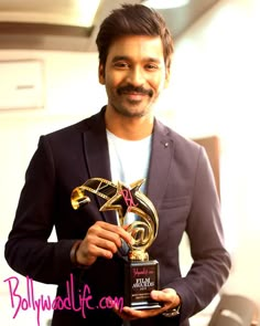 the man is holding an award for his role in the film's upcoming movie