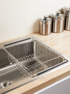 a stainless steel kitchen sink with an overflowing strainer in front of it