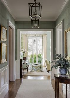 an open door leading to a living room with green walls and white trimmings