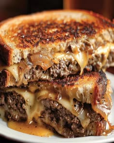 a grilled cheeseburger on a white plate with melted cheese and onions in the middle