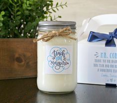 a jar filled with white liquid sitting on top of a table next to a box