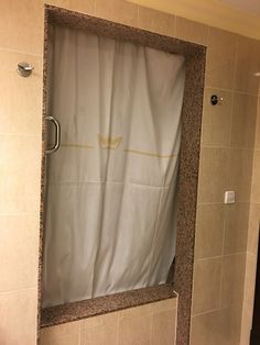 a bathroom with a shower curtain and toilet paper dispenser on the wall