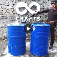 a man standing next to two blue barrels with water coming out of them and the words cranis on it