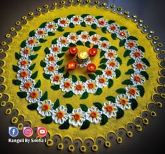 a yellow and white circular design with two candles on the center, surrounded by flowers