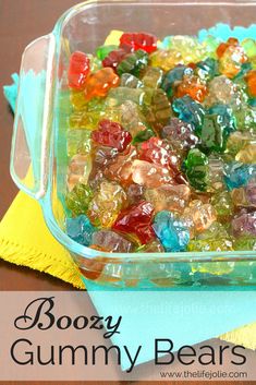 a glass dish filled with gummy bears sitting on top of a yellow cloth next to a