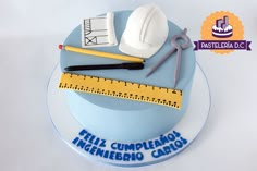 there is a cake that has construction tools on it and the words feliz cumplemos ingeniero