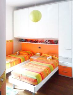 two beds in a room with orange and white decor