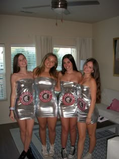 four girls in shiny silver dresses posing for the camera