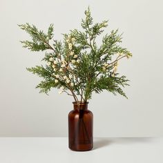 a brown vase filled with white flowers on top of a table