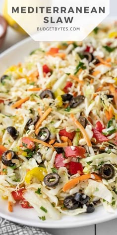 a white plate topped with coleslaw and olives