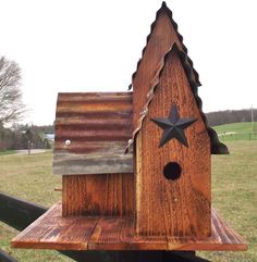 a wooden birdhouse with a star on the roof