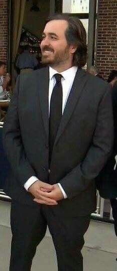 a man in a suit and tie standing on the sidewalk