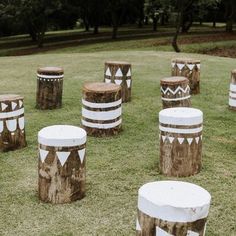 several wooden stools sitting on top of a grass covered field next to each other