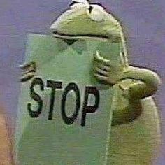 a frog holding a sign that says stop