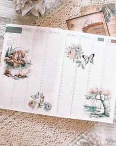 an open planner is sitting on a doily next to flowers and other things that are scattered around it