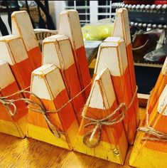 several orange and white wooden pieces tied up with twine on top of a table