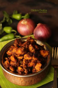 a bowl filled with fried food next to some onions and green peppers on a table