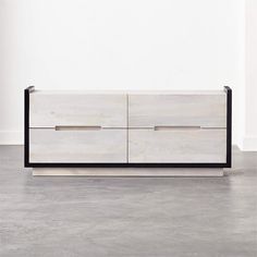 a white and black dresser sitting on top of a floor