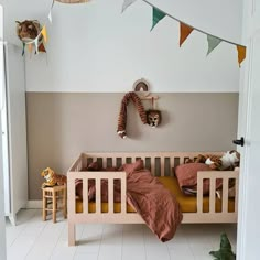 there is a baby crib in the room with two stuffed animals hanging from the ceiling