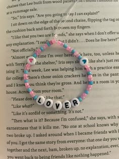 an open book with a bracelet that says love on it and the words i'm sorry written in small letters