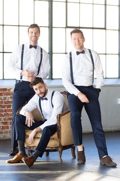 two men in white shirts and blue pants are posing for the camera while sitting on a chair