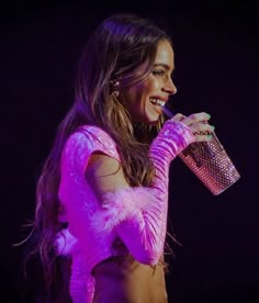 a woman in pink dress holding a microphone