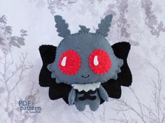 a close up of a stuffed animal with red eyes on a white wallpaper background