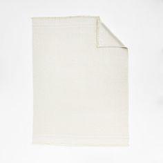 a white blanket folded on top of a table