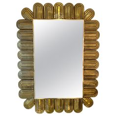 a mirror that is sitting on top of a white surface with gold trimmings