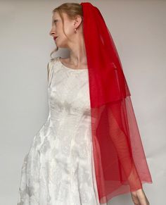 a woman in a white dress and red veil