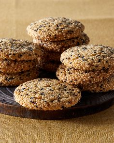 some cookies are stacked on top of each other in front of a wooden plate with black speckles