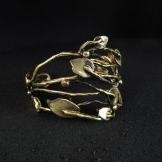 - Brass - Adjustable - Nickel Free, Hypoallergenic, Non Tarnish ----Planta Cuff---- Myri collection Handmade, hand forged, non tarnish adjustable Planta Cuff. Intricate organic design resembling leaves and branches. Colors: gold and black. - limited number  MATERIAL: Brass, Nickel Free & Hypoallergenic, Non Tarnish  SIZE: Adjustable Height Approx. 1.7″  =  45mm  SUGGESTED CARE: Use water and a drop of mild detergent. Rinse, then dry. Always make sure to wipe off water and dry your jewelry comple Hand Forged Gold Cuff Bracelet As Gift, Hand Forged Metal Cuff Bracelet As Gift, Unique Bronze Bangle As Gift, Unique Bronze Bangle For Gift, Gold Bangle Cuff Bracelet In Wearable Art Style, Hand Forged Brass Cuff Bracelet For Gift, Yellow Gold Brass Cuff Bracelet Gift, Yellow Gold Brass Cuff Bracelet As Gift, Handmade Gold Bangle In Wearable Art Style