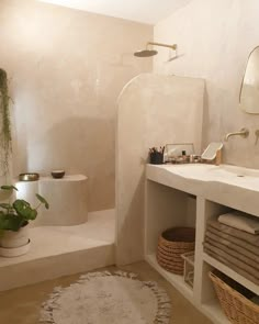 a bathroom with a sink, toilet and bathtub next to a plant on the floor