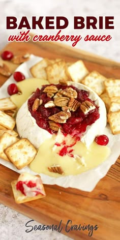 baked brie with cranberry sauce and crackers on a wooden cutting board