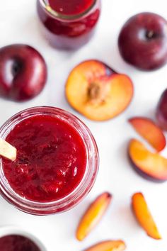 a jar filled with red liquid next to sliced peaches