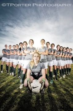 a woman kneeling down in front of a soccer team