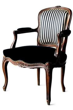 an antique chair with black and white striped upholstered fabric on the armrests