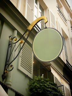 a sign that is attached to the side of a building with shutters on it