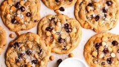 chocolate chip cookies with nuts and sea salt are arranged next to a cup of milk